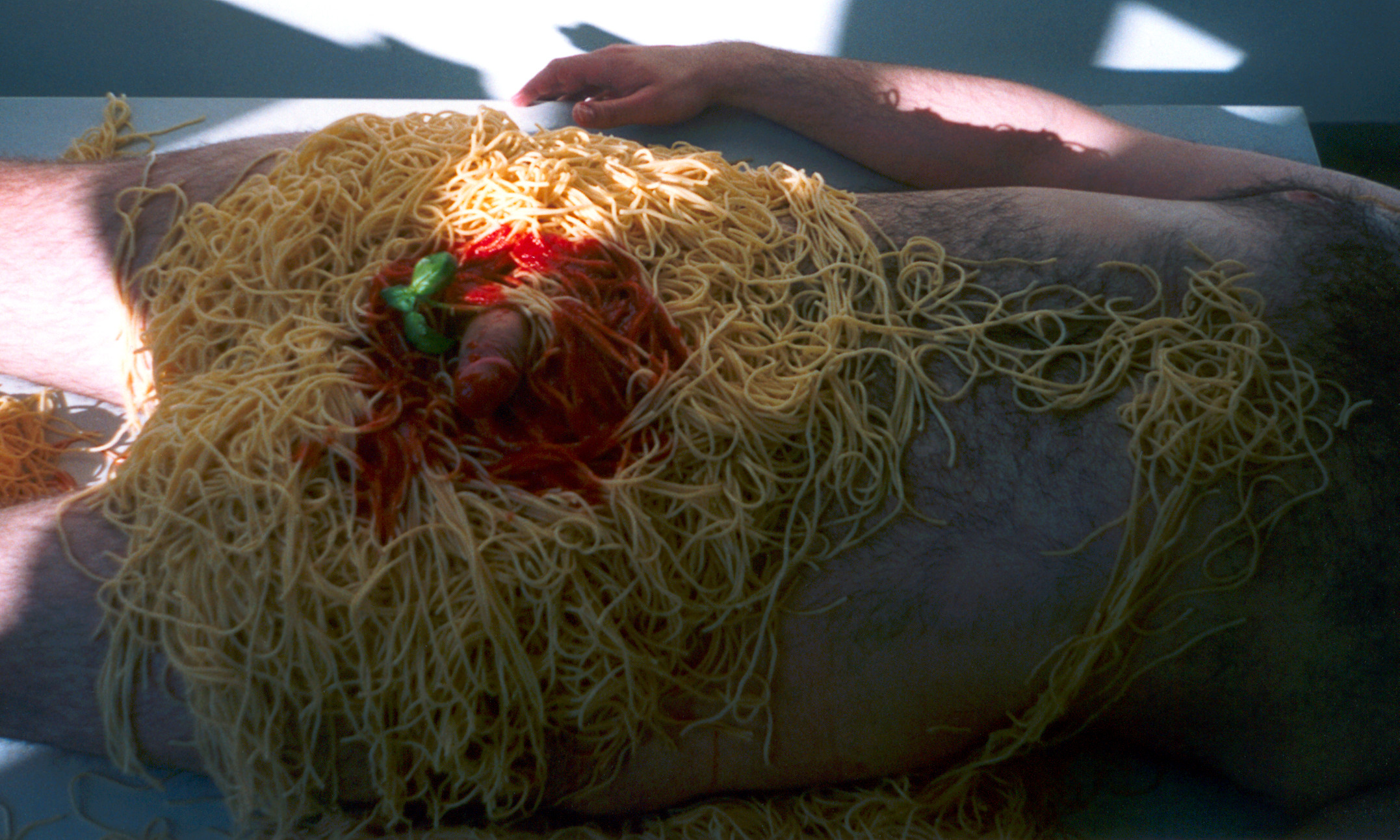 Nackter Mann in Spaghetti mit Tomatensoße (Foto)